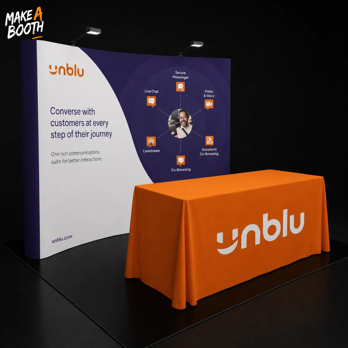 Curved pop-up fabric display table with orange printed cover and rounded corners